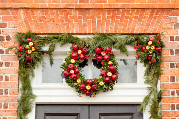 Традиционный вариант - повесить рождественский венок на входную дверь или над нею